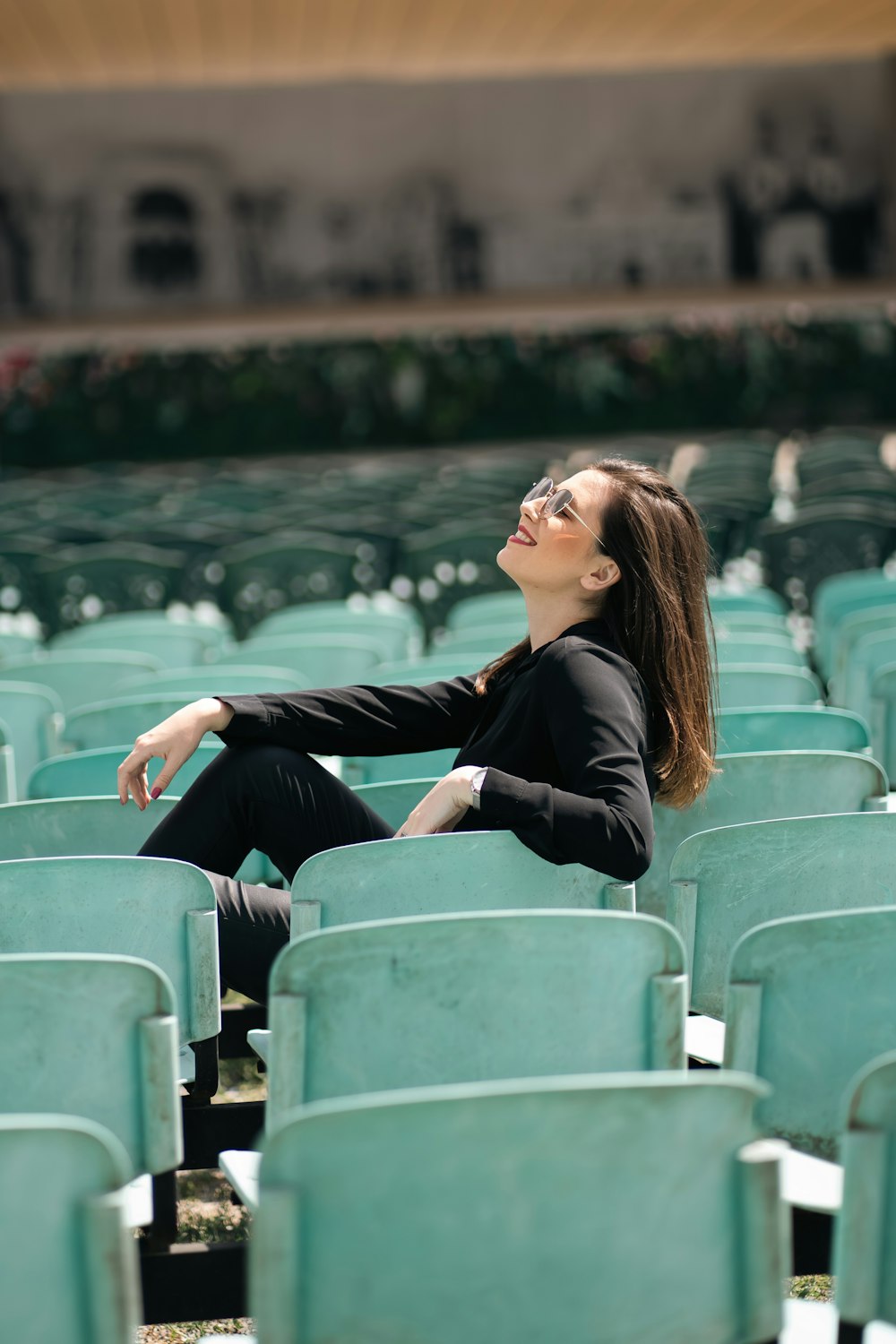 a woman sitting in a row of green chairs
