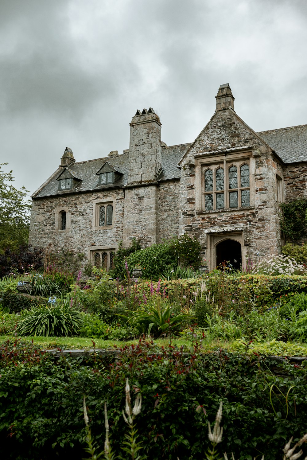 an old stone house with a garden in front of it