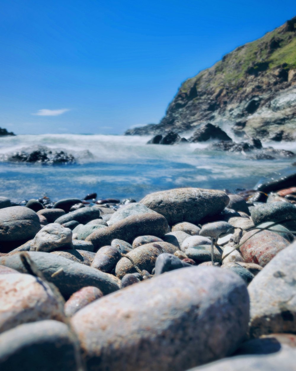 rocks and water on a rocky beach with a cliff in the background