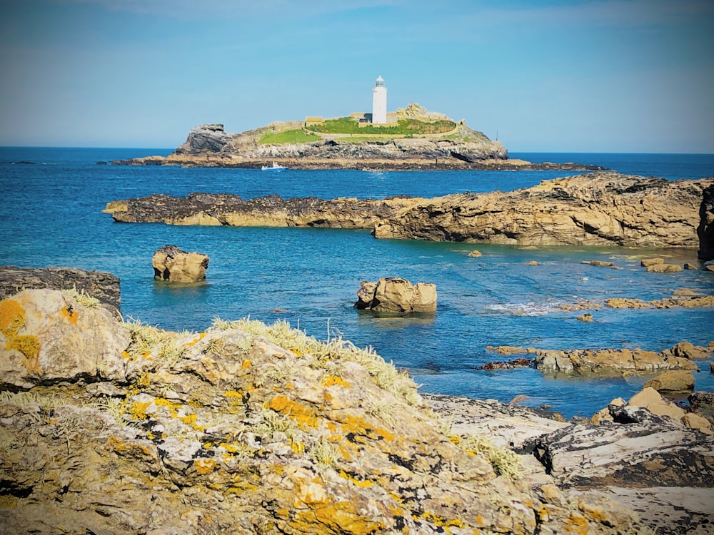 a lighthouse on an island in the middle of the ocean