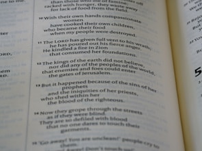 A close-up view of an open book displaying text in two columns. The text is printed in black on cream-colored pages and appears to be from a religious or historical document, given the mention of 'The LORD' and references to events involving kings and nations.