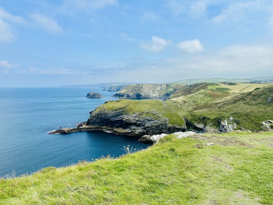 A grassy hill with a body of water in the background — Cornwall, United Kingdom