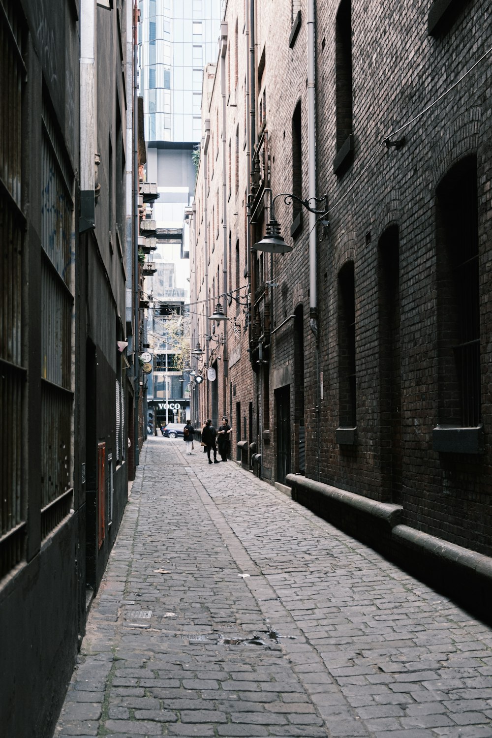 a narrow alley way with people walking down it