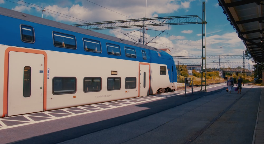 a blue and white train stopped at a train station