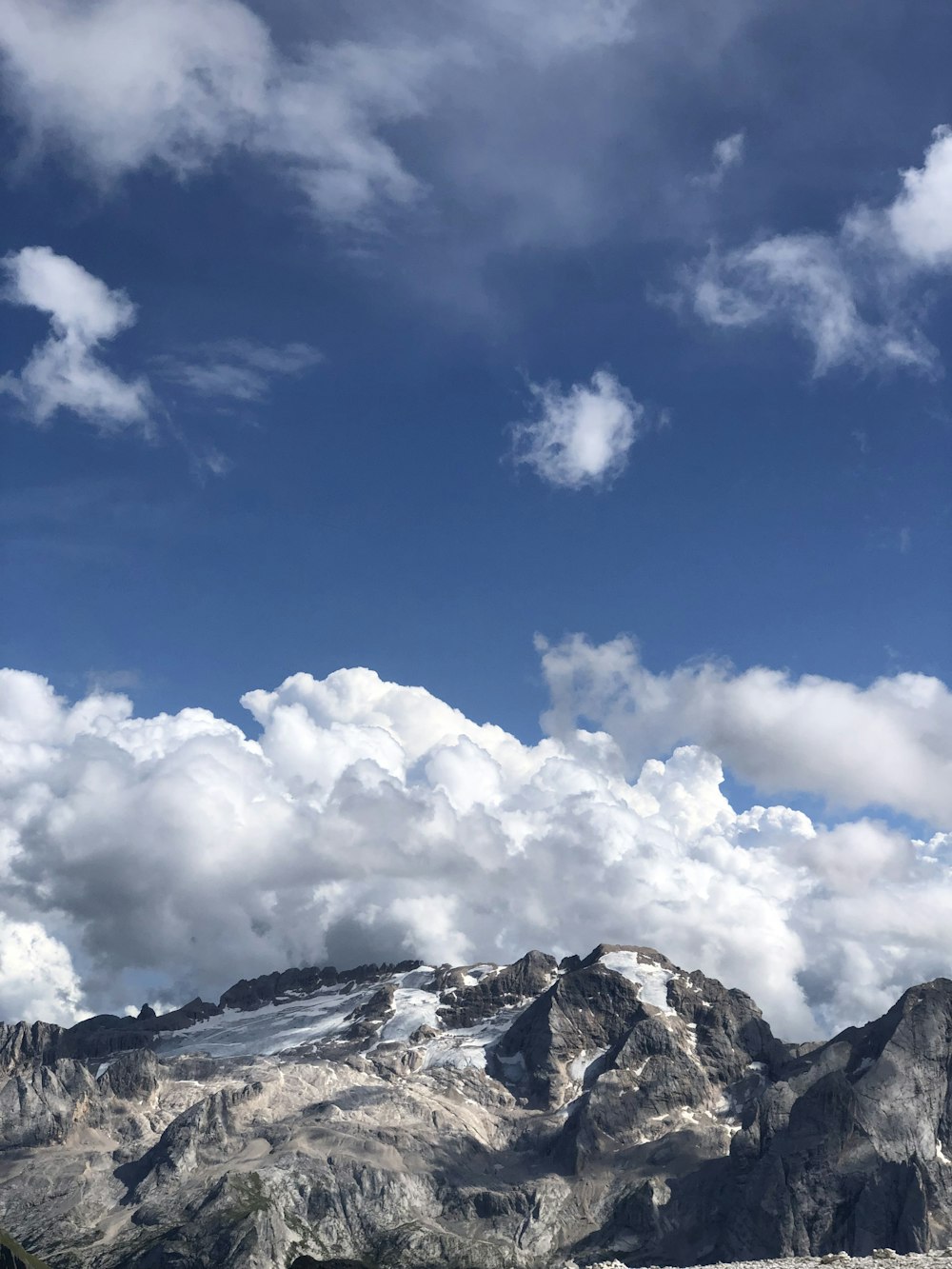 a mountain range with a few clouds in the sky