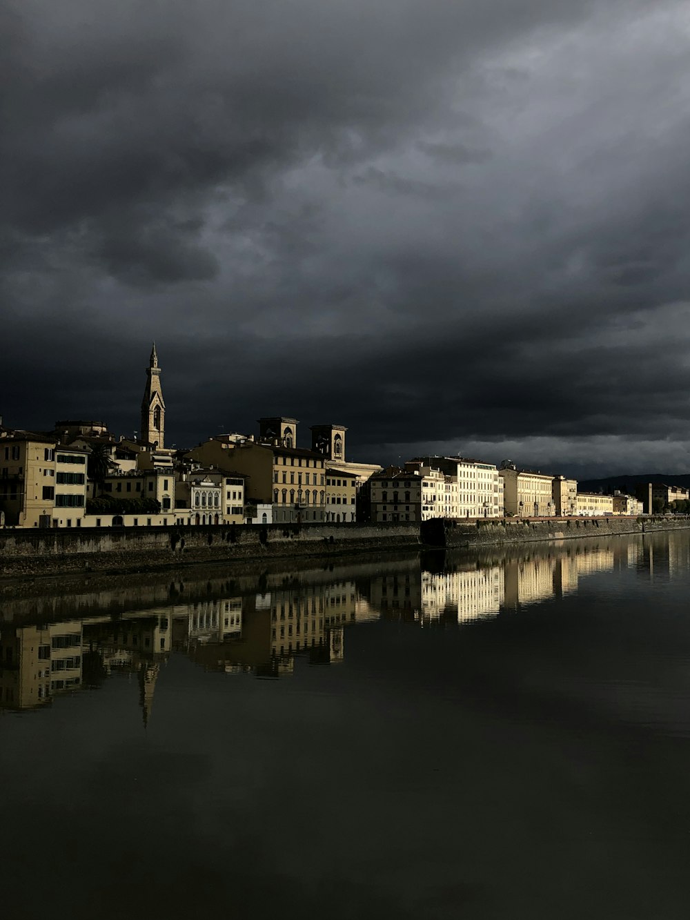 a dark sky is reflected in a body of water