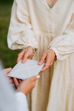 a woman in a white dress holding a piece of paper