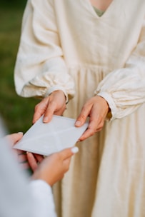 a woman in a white dress holding a piece of paper