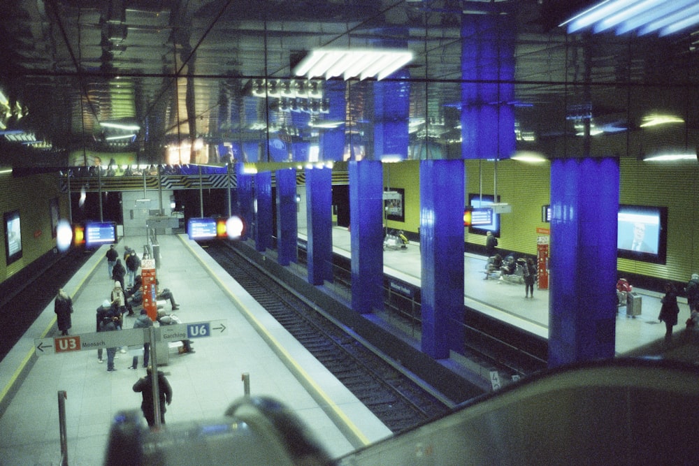 a train station with people waiting for their trains