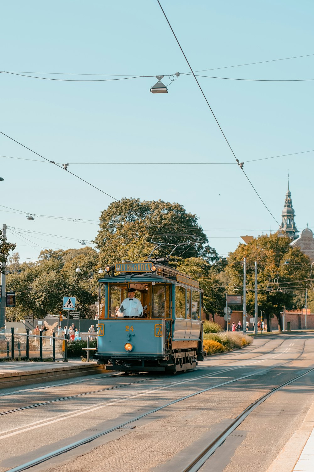 a blue trolley car traveling down a street