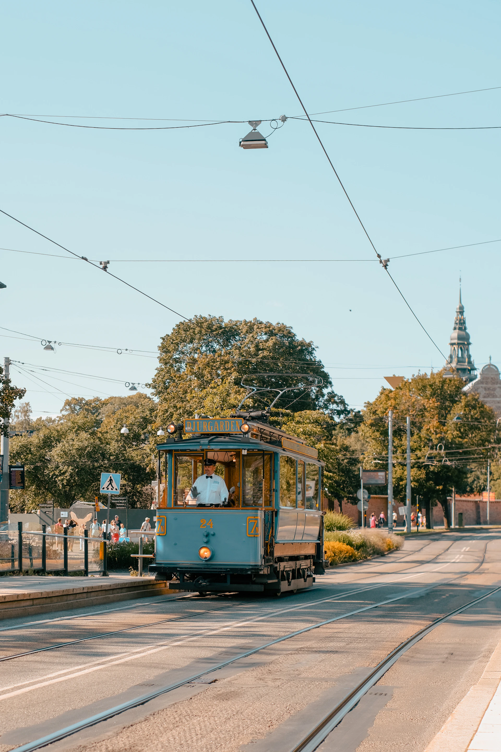 a blue trolley car traveling down a street