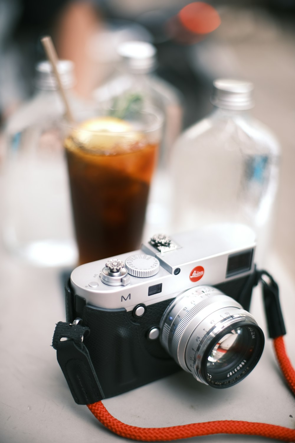 a camera sitting on top of a table next to a drink