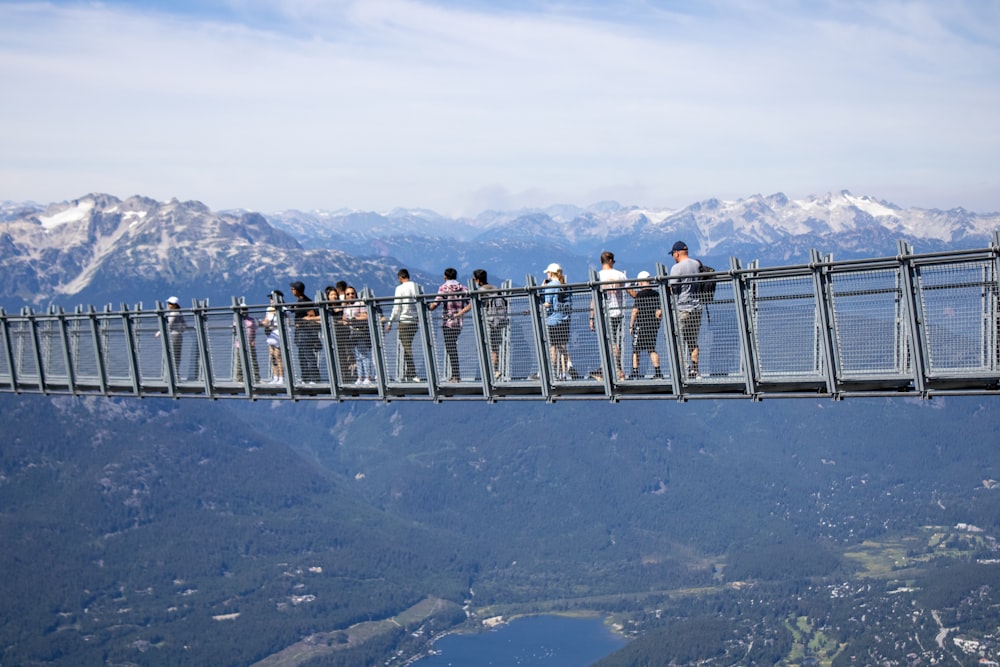 a group of people standing on top of a bridge