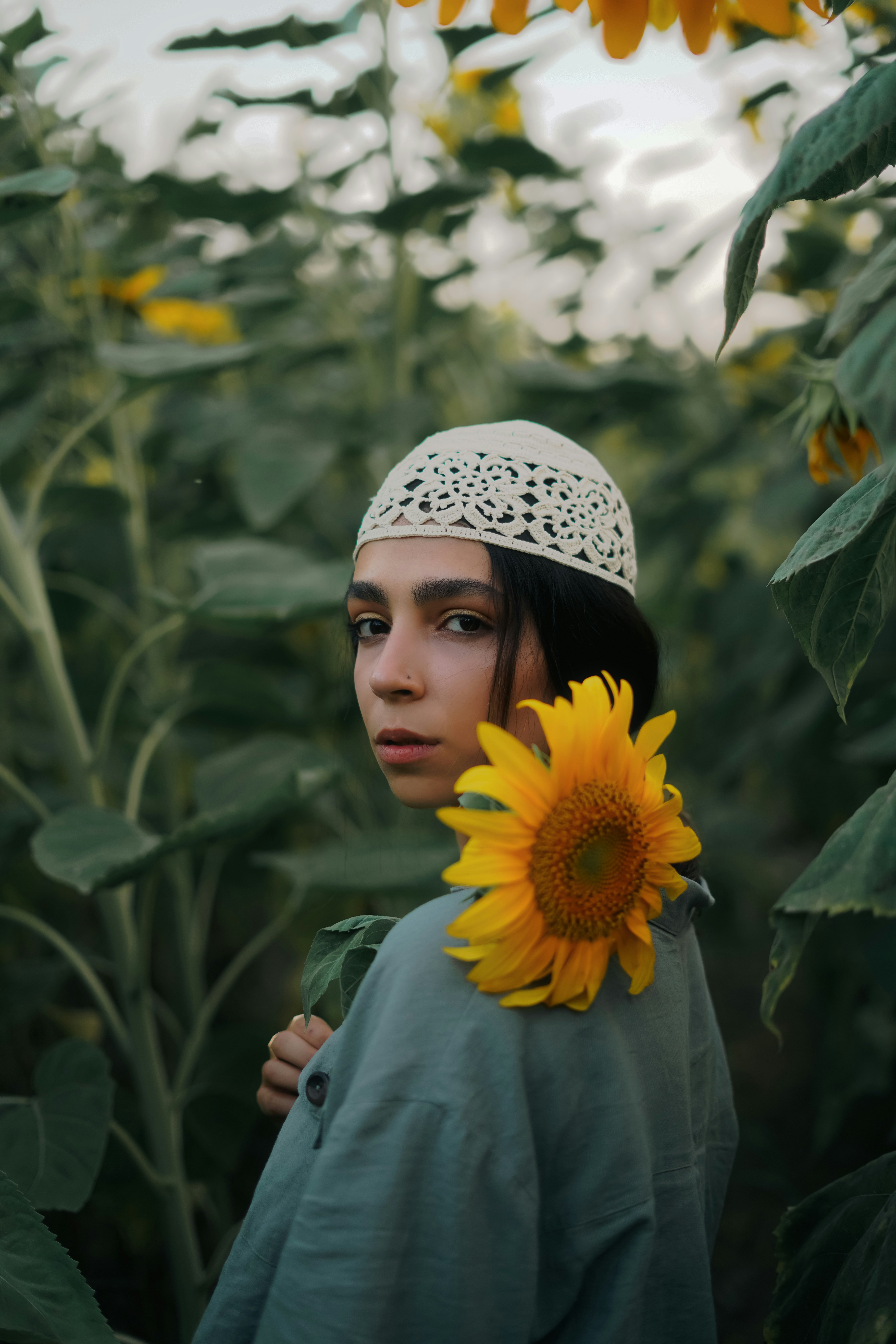 eine frau, die in einem feld von sonnenblumen steht
