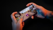 Close-up of a hand holding a smartphone with the Jalwa game interface visible.
