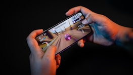 Close-up of a hand holding a smartphone with the Jalwa game interface visible.