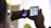 A person is interacting with two electronic devices; a smartwatch on their wrist displaying the time and a cartoon image, and a foldable smartphone showcasing sleep tracking data with graphs and time details. The setting is indoors with soft lighting.