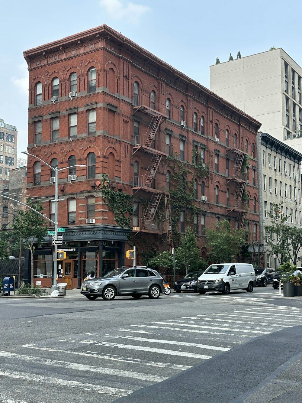 Un gran edificio de ladrillo rojo sentado en la esquina de una calle