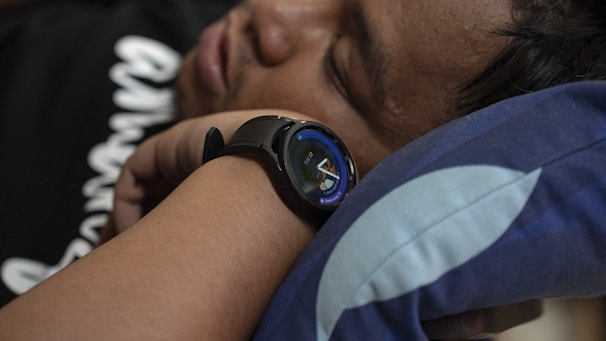 Person sleeping peacefully wearing a smart health device on their wrist.