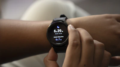 Close-up of hands adjusting a sleep tracking device on a patient's wrist.
