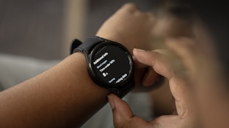 A person is wearing a smartwatch on their wrist, with the display showing health-related information such as blood oxygen levels and time under 90%. The person is interacting with the watch, touching the screen with their fingers.