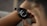A person is wearing a smartwatch on their wrist, with the display showing health-related information such as blood oxygen levels and time under 90%. The person is interacting with the watch, touching the screen with their fingers.