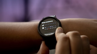A person is interacting with a smartwatch on their wrist, displaying sleep consistency information through a graph with numerical data.