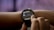 A person is interacting with a smartwatch on their wrist, displaying sleep consistency information through a graph with numerical data.