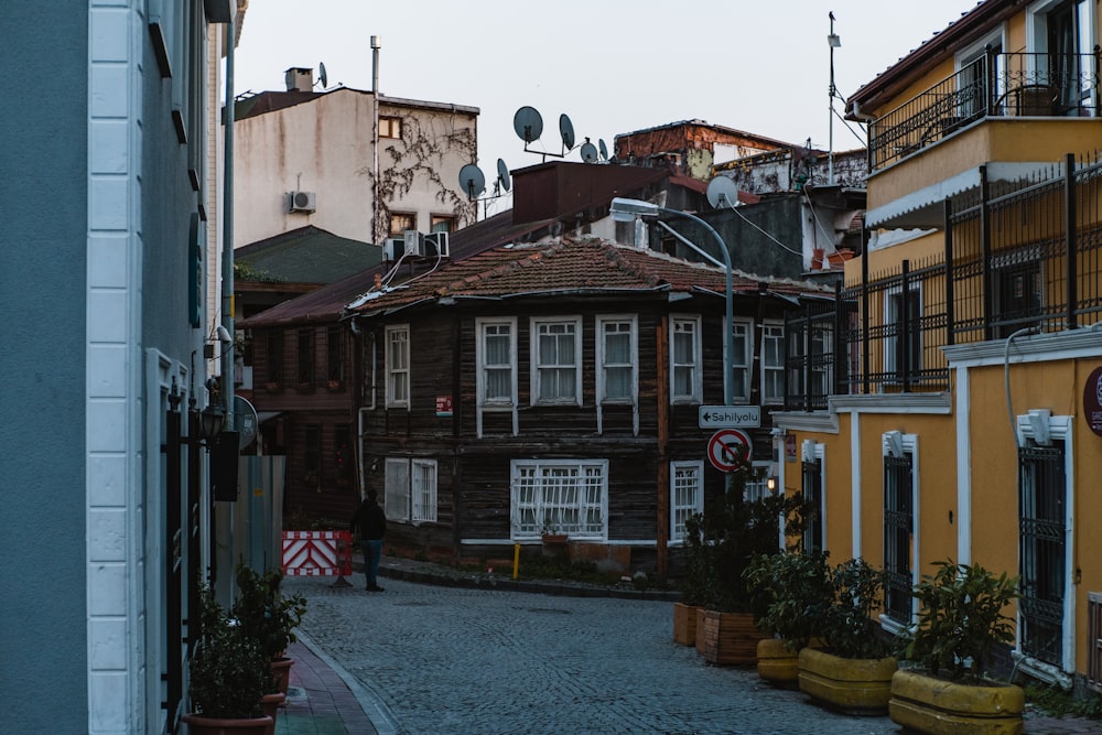 a cobblestone street lined with buildings and potted plants