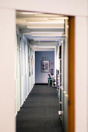 Office corridor illuminated by emergency lights with visible fire alarm panels.