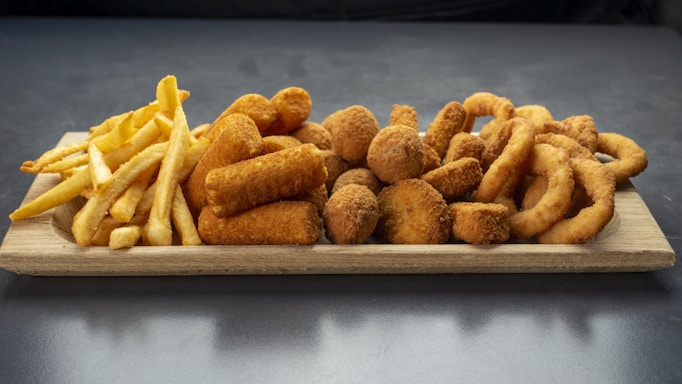 A colorful platter of assorted fried foods including wings, shrimp, and fries.
