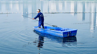 A team member smiling while operating a water fed pole against a bright blue sky.