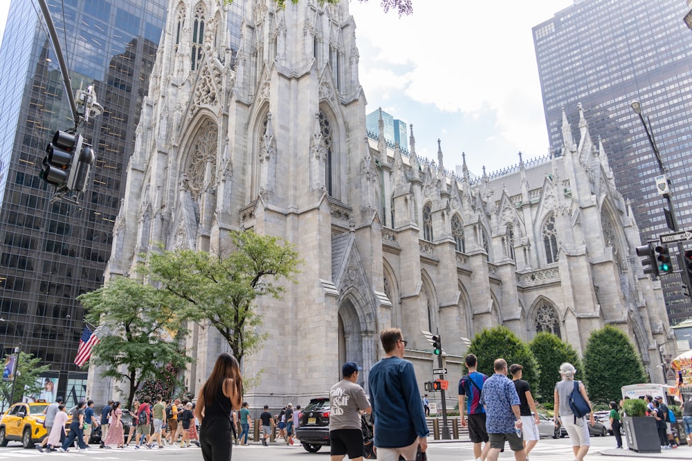 a group of people walking in front of a cathedral
