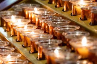 Small votive candles in glass holders, arranged for a festive event.