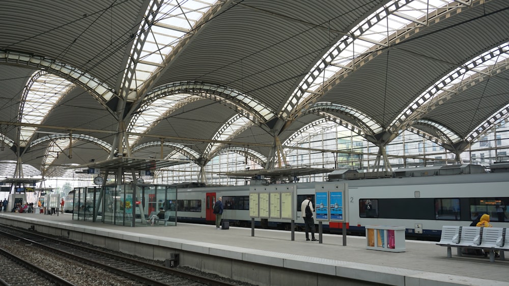 a train station with people waiting for their trains