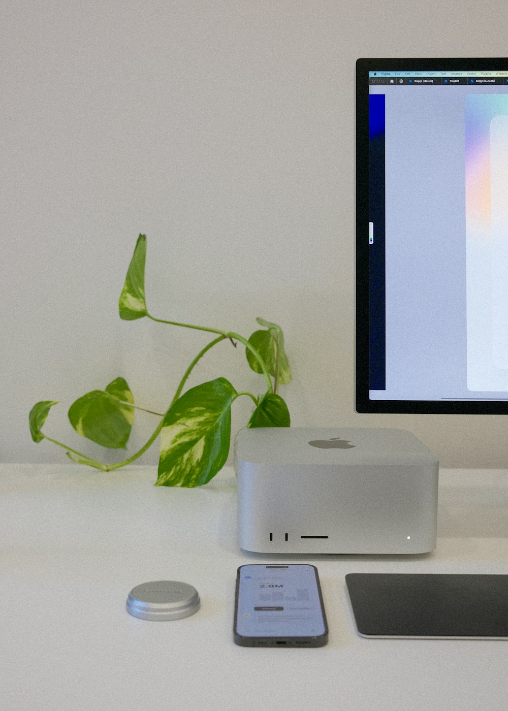 a computer monitor sitting on top of a desk next to a cell phone