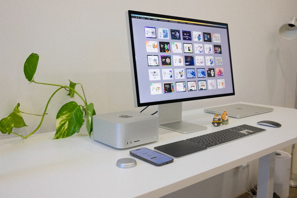 Un monitor de computadora sentado encima de un escritorio blanco