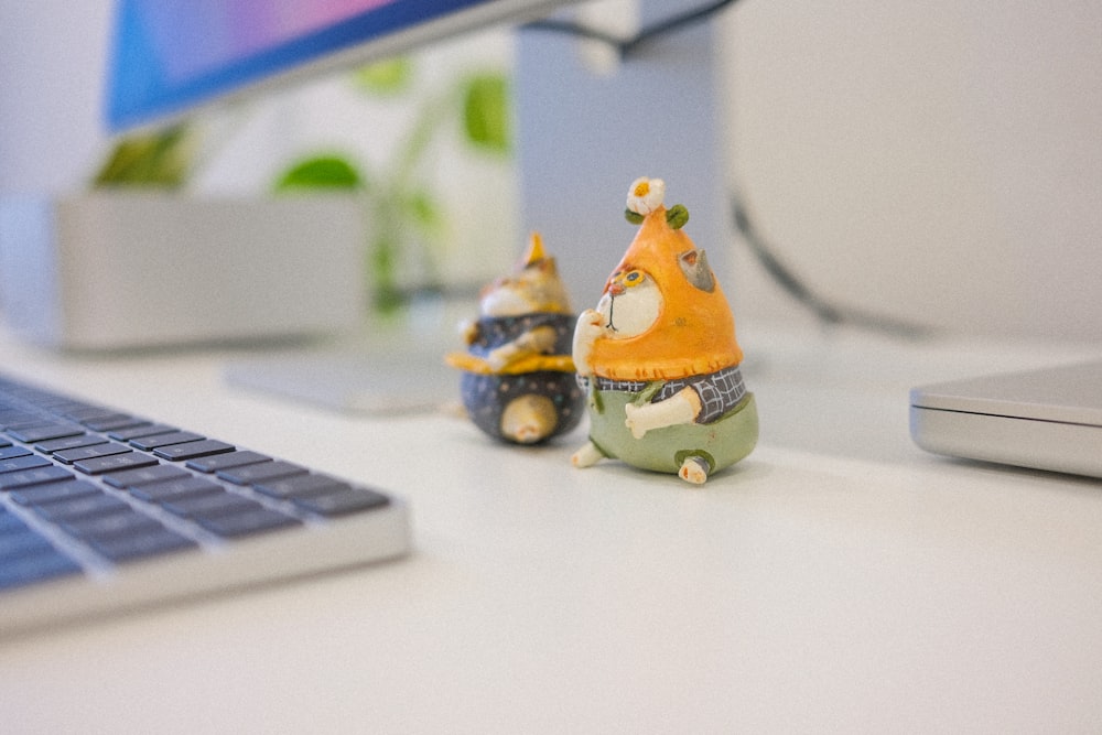 a couple of small figurines sitting on top of a desk
