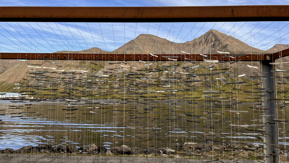 a wooden bridge over a body of water with mountains in the background
