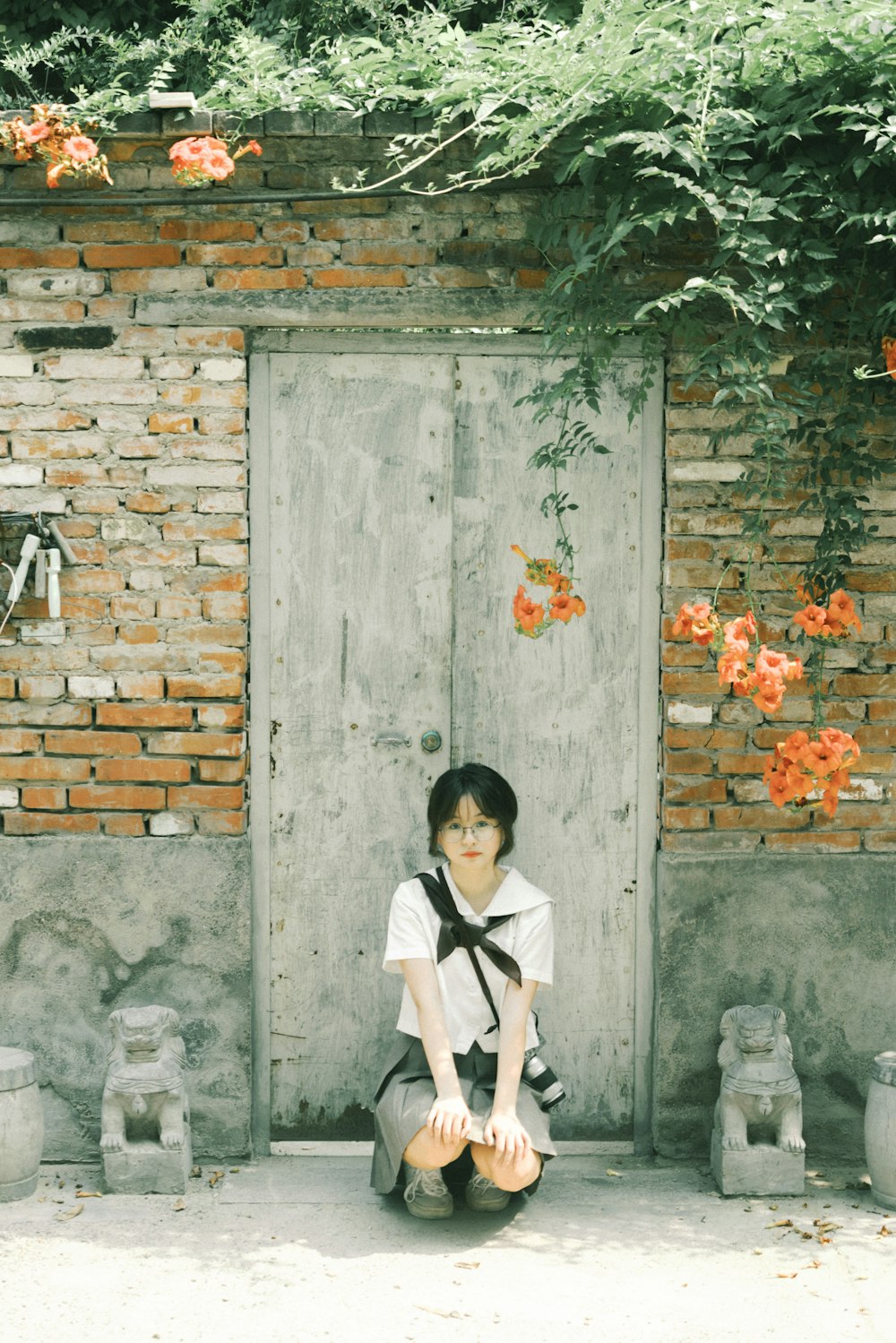 a woman sitting on the ground in front of a door