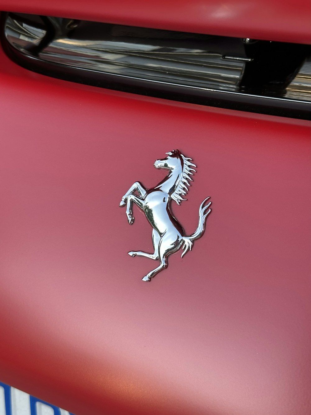 El emblema en la parte delantera de un coche rojo