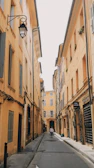 a person walking down a narrow street between two buildings