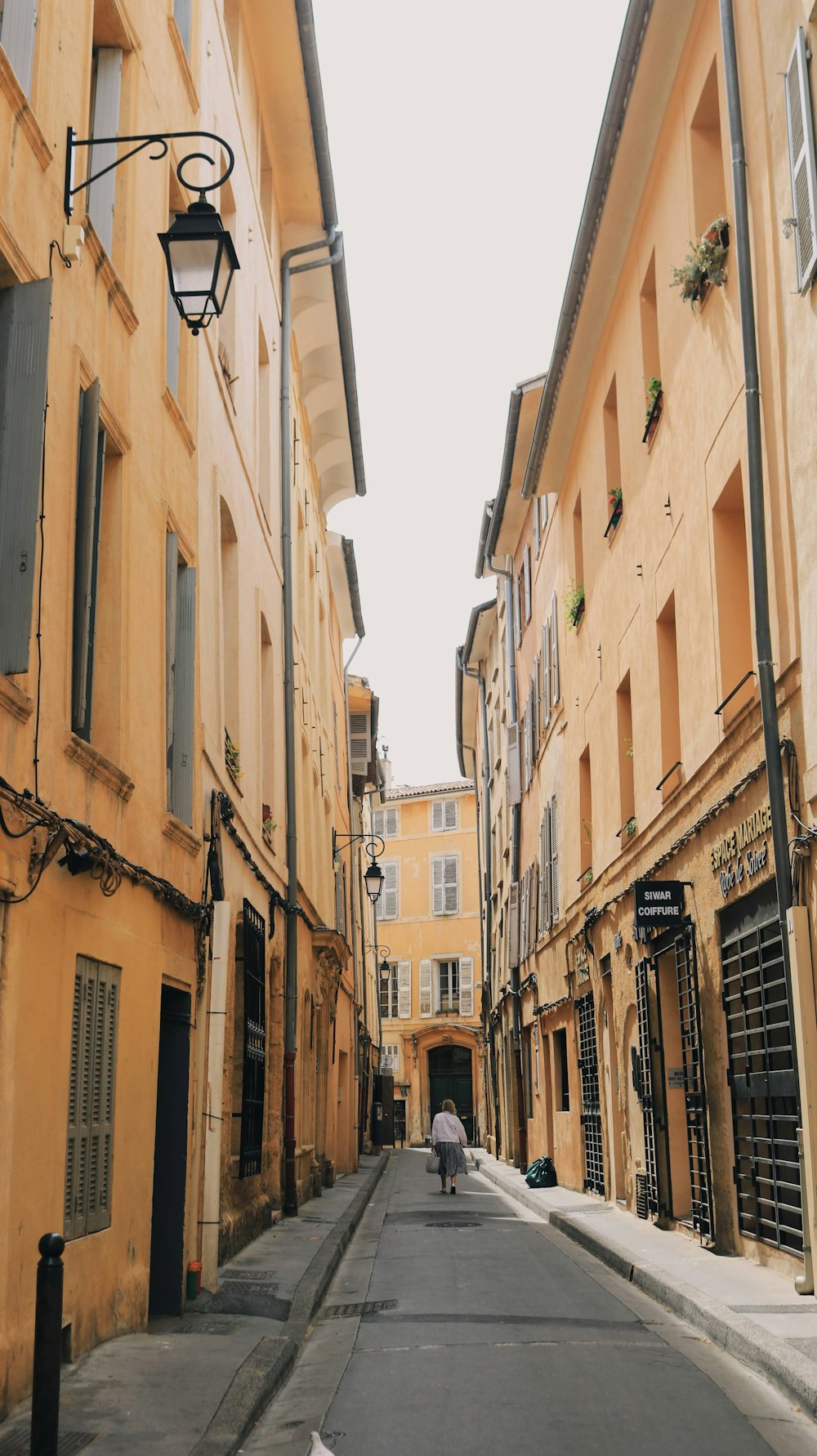 a person walking down a narrow street between two buildings