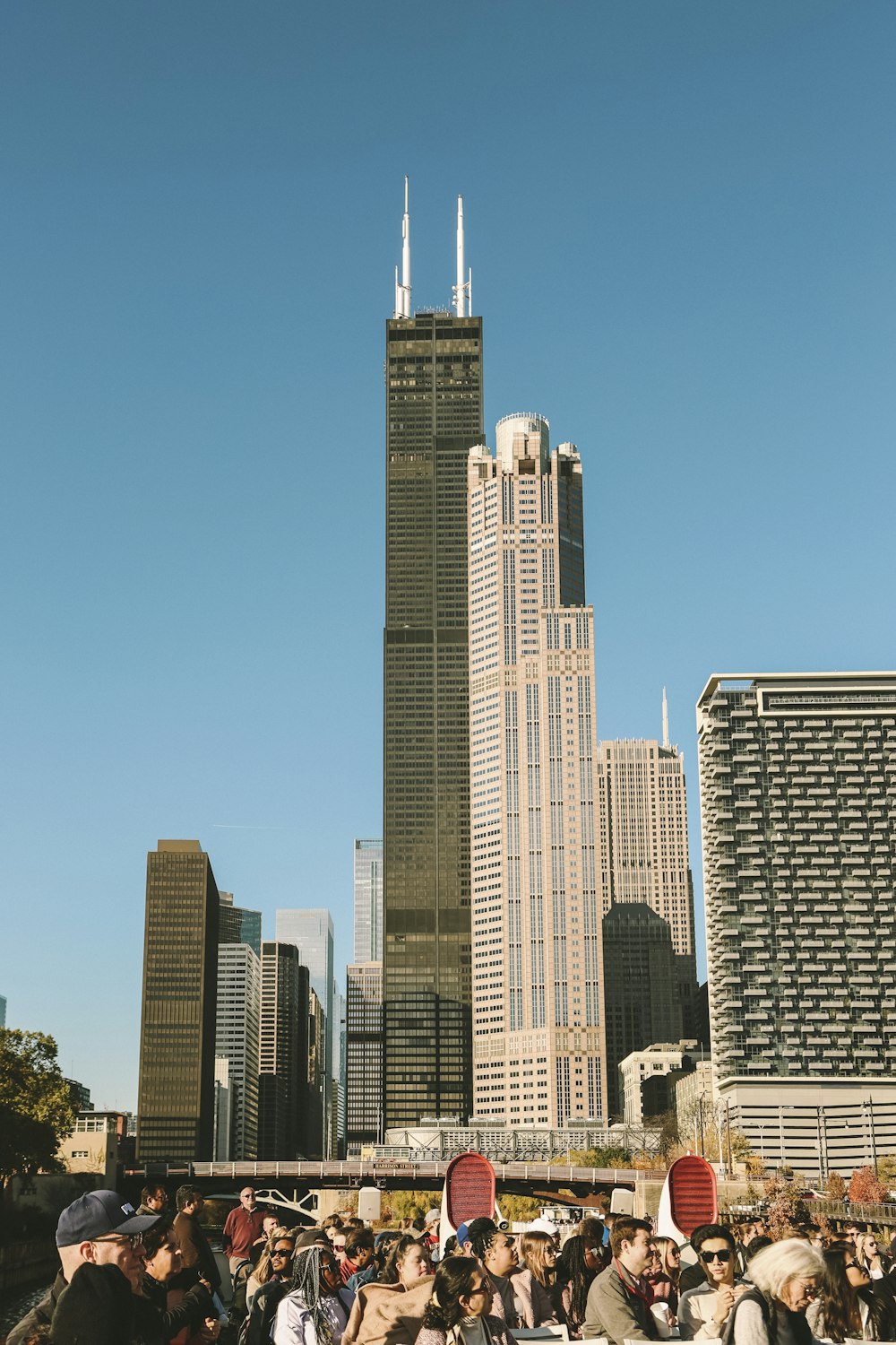 Una multitud de personas de pie frente a un edificio alto