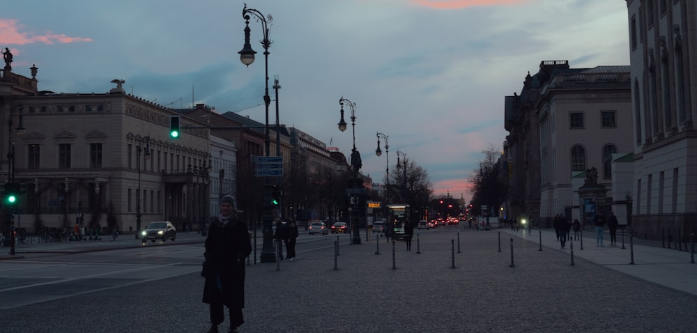 a man standing on the side of a street next to a traffic light