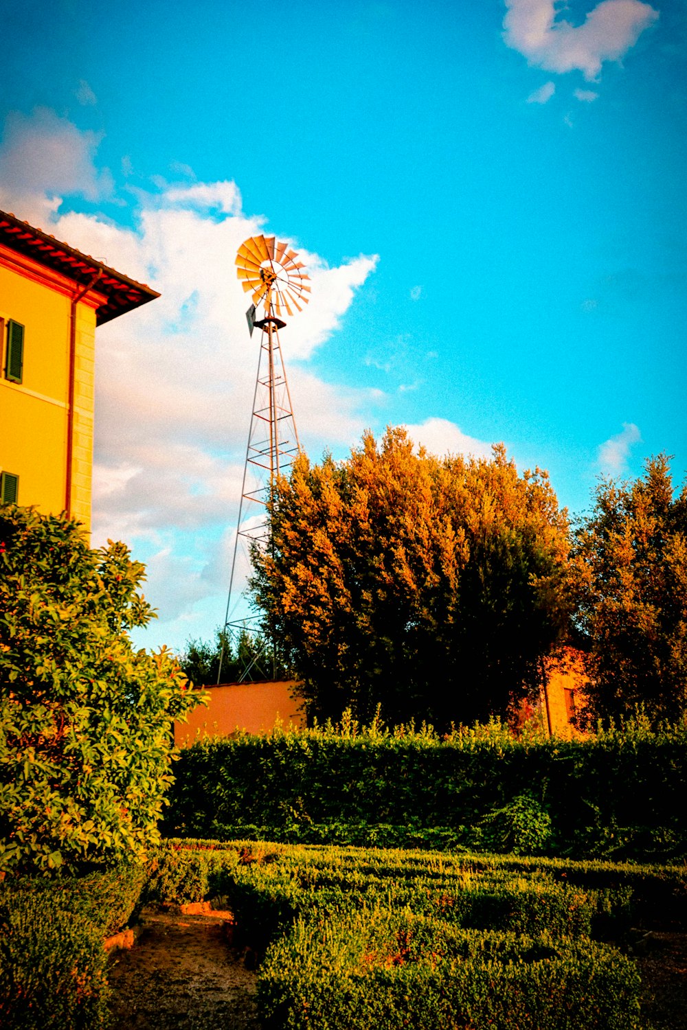 a windmill sitting on top of a lush green field