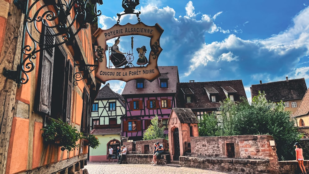 a street scene with people walking around and a clock on the side of a building