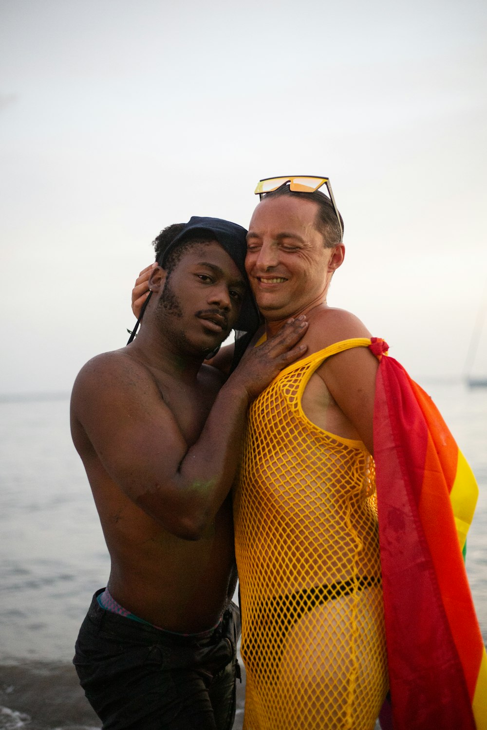 a couple of men standing next to each other on a beach