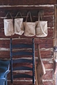 Earthpeak caps displayed on rustic hooks against a textured wall.