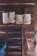 Cotton tote bags with vibrant graphic designs hanging on a rustic wall